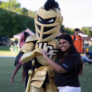 Impact picture, Knightro with student, using hands to form a heart shape